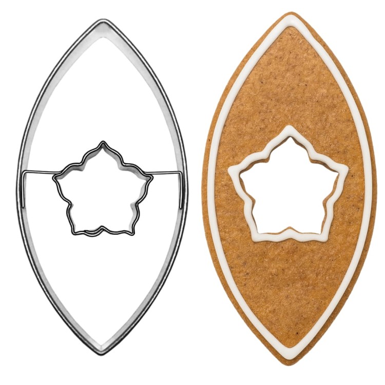 Metalowa foremka w kształcie listka z dziurką w kształcie róży z wykrojonym piernikiem obok