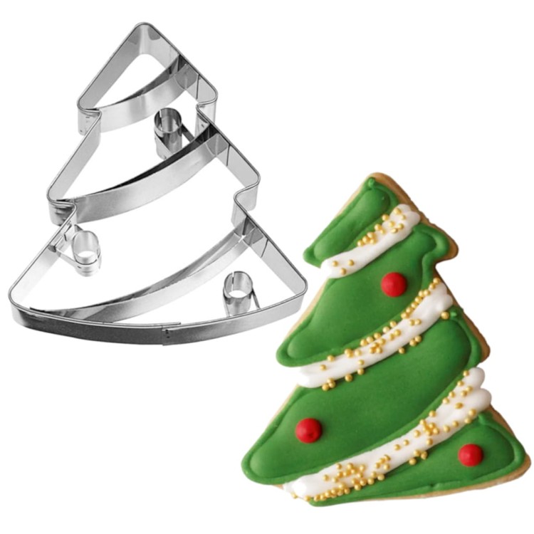 Ciasteczko w kształcie choinki obok wykrawacza – dekoracja świąteczna z lukrem i posypką