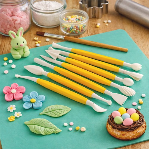 Szpatułki do dekoracji cukrowych w trakcie modelowania z masy cukrowej na stole roboczym