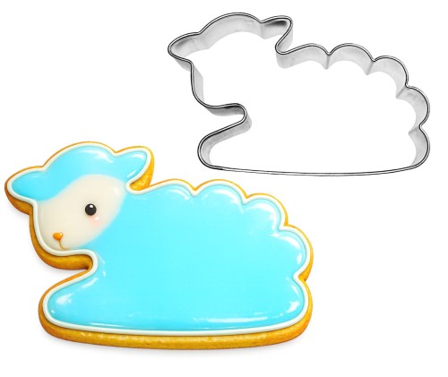 Metalowa foremka owca leżąca obok lukrowanego ciasteczka wykonanego foremką