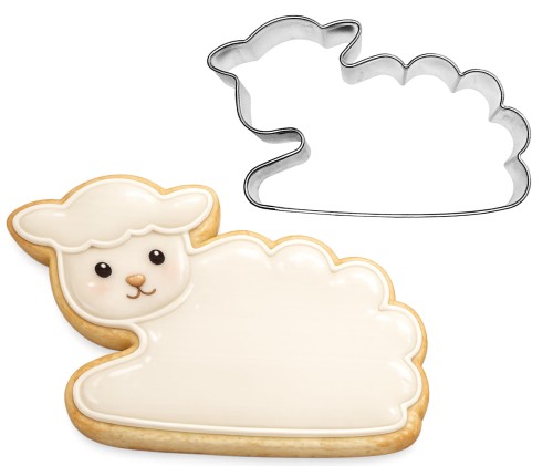 metalowa foremka owca leżąca obok białego lukrowanego ciasteczka wykonanego foremką
