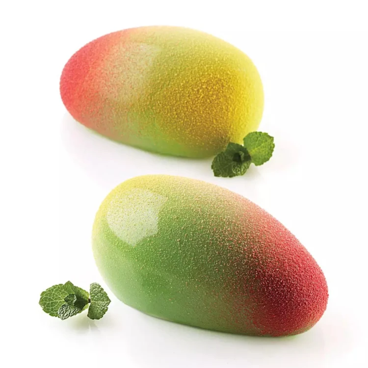 Monoporcje w kształcie mango o gładkiej, błyszczącej powierzchni w zielono‑żółto‑czerwonym odcieniu, ułożone na białej powierzchni.