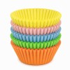 Pastelowe mini foremki do muffinek ułożone w kolorowy stos, w odcieniach żółtym, różowym, niebieskim, zielonym i pomarańczowym.